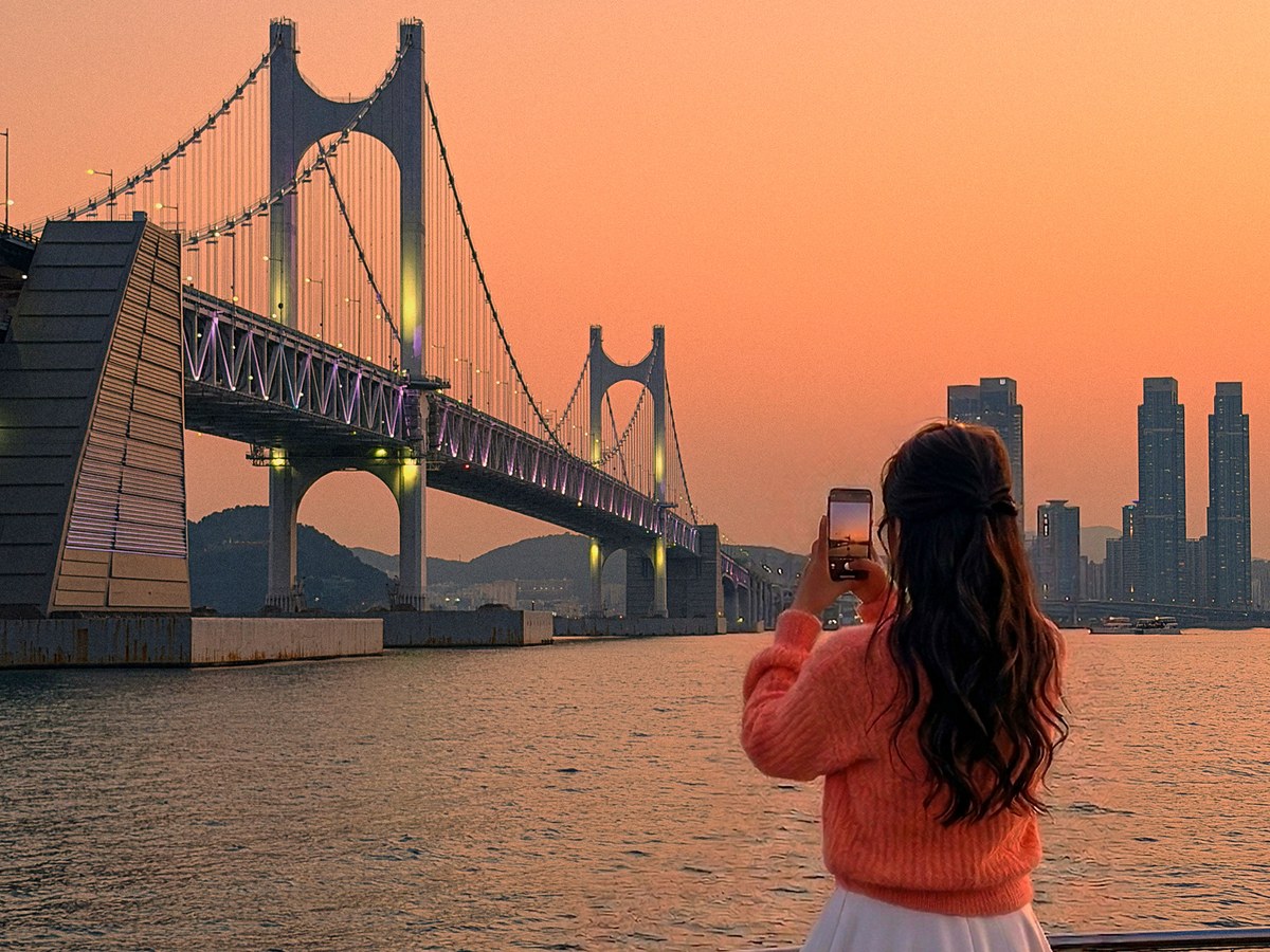 黄金色の夕焼けと広安大橋を写真に収めるお客様