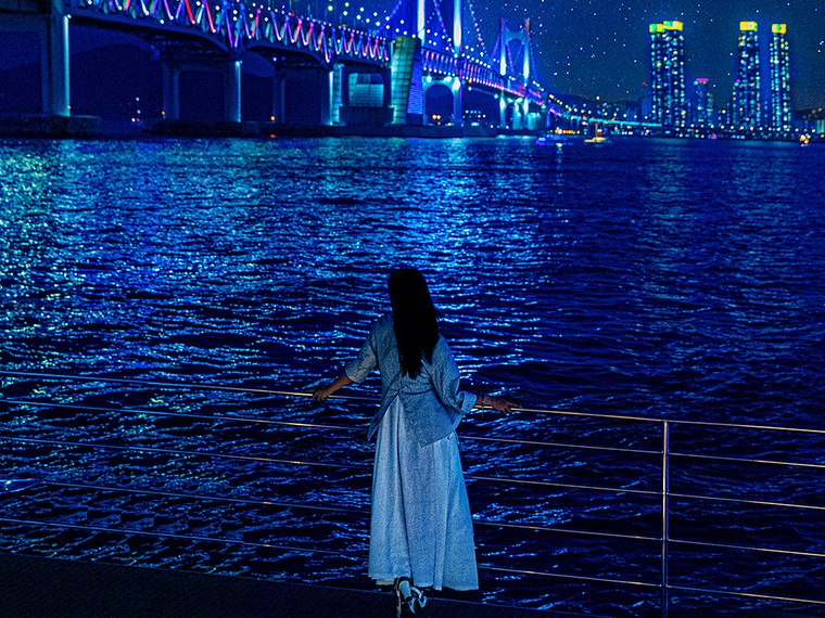 夜の海の上でドローンショーを見るお客様